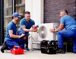 HVAC team positioning and inspecting a compact outdoor air conditioning unit